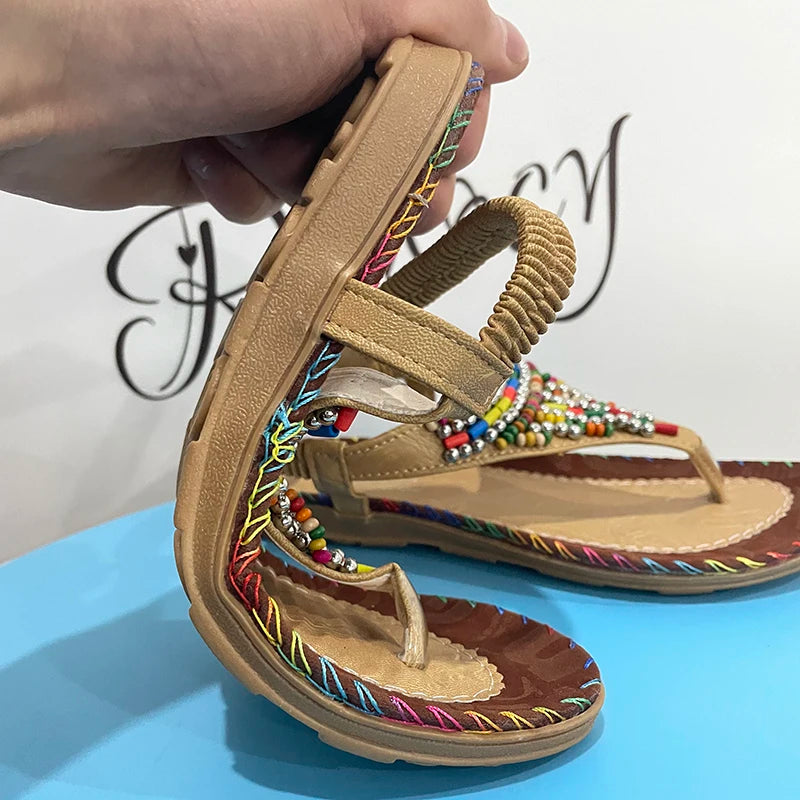 a person is holding a pair of sandals