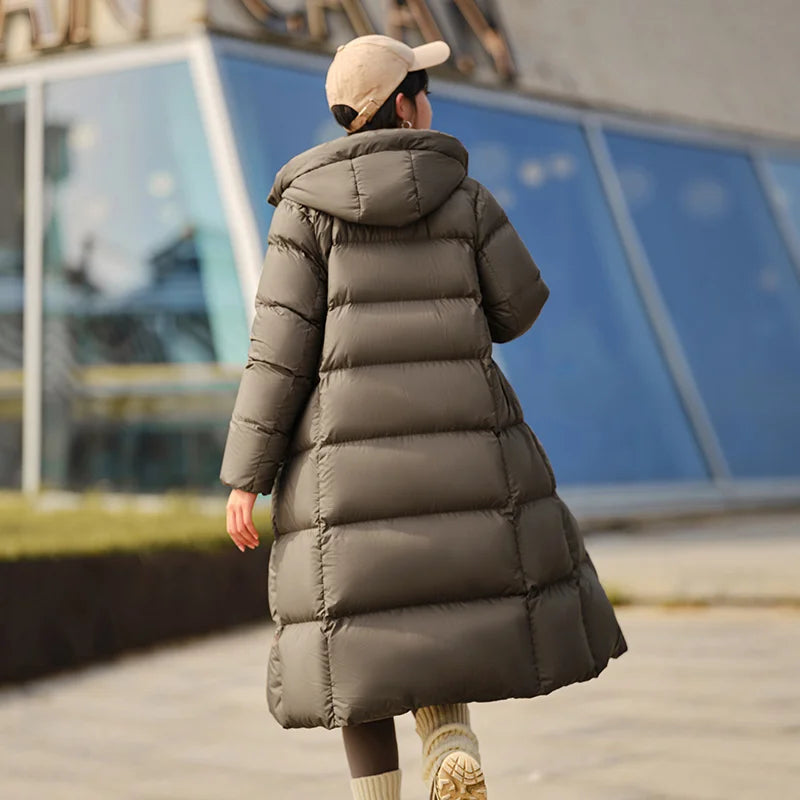 a woman walking down a sidewalk in a long coat