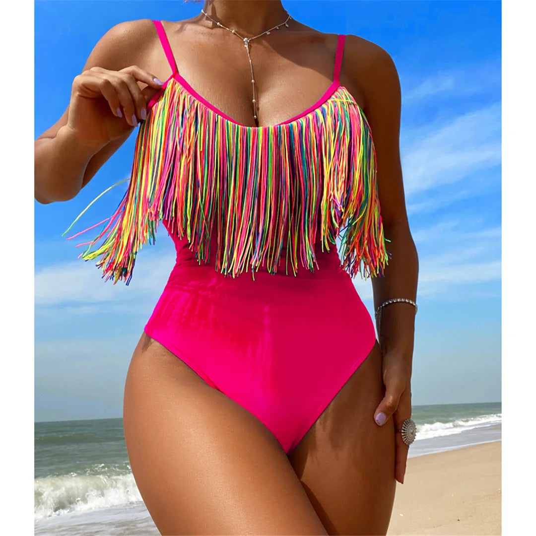 a woman in a pink one piece swimsuit on the beach