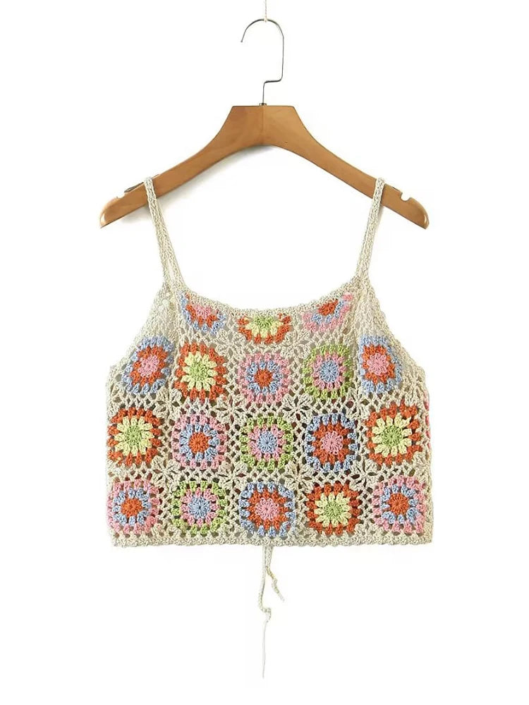 a crocheted top hanging on a wooden hanger