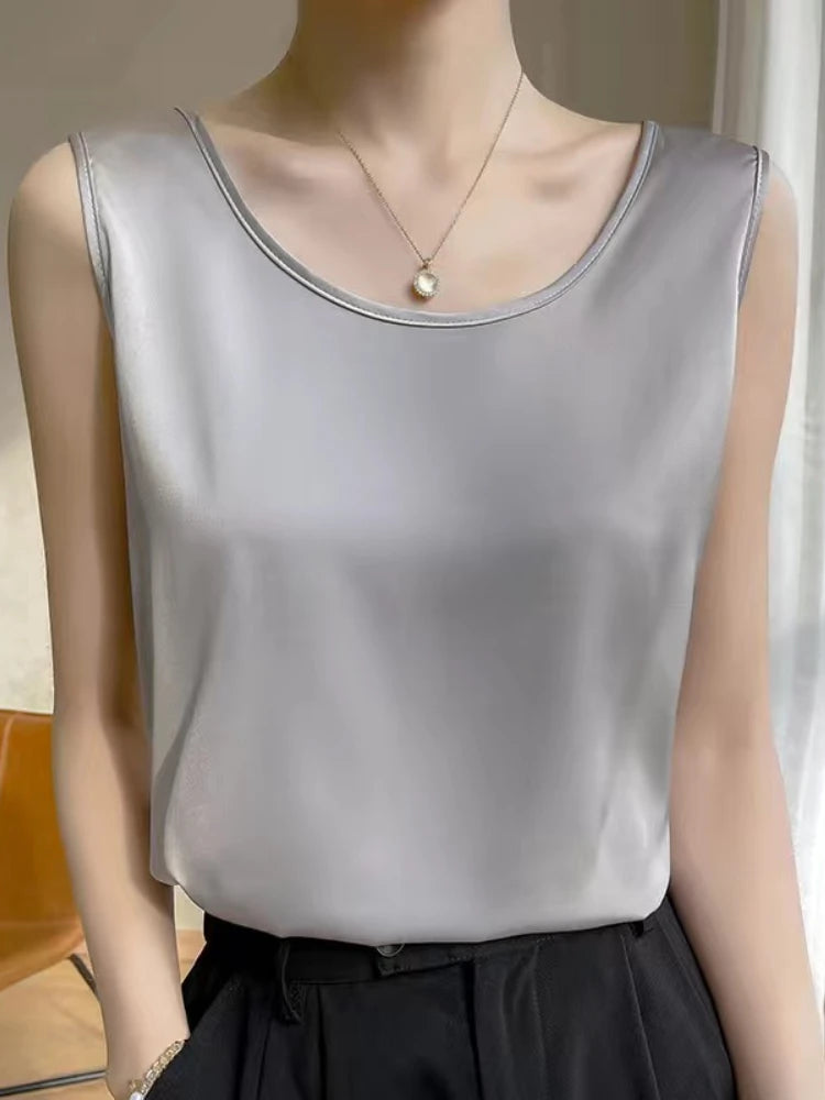 a woman wearing a silver top and black pants