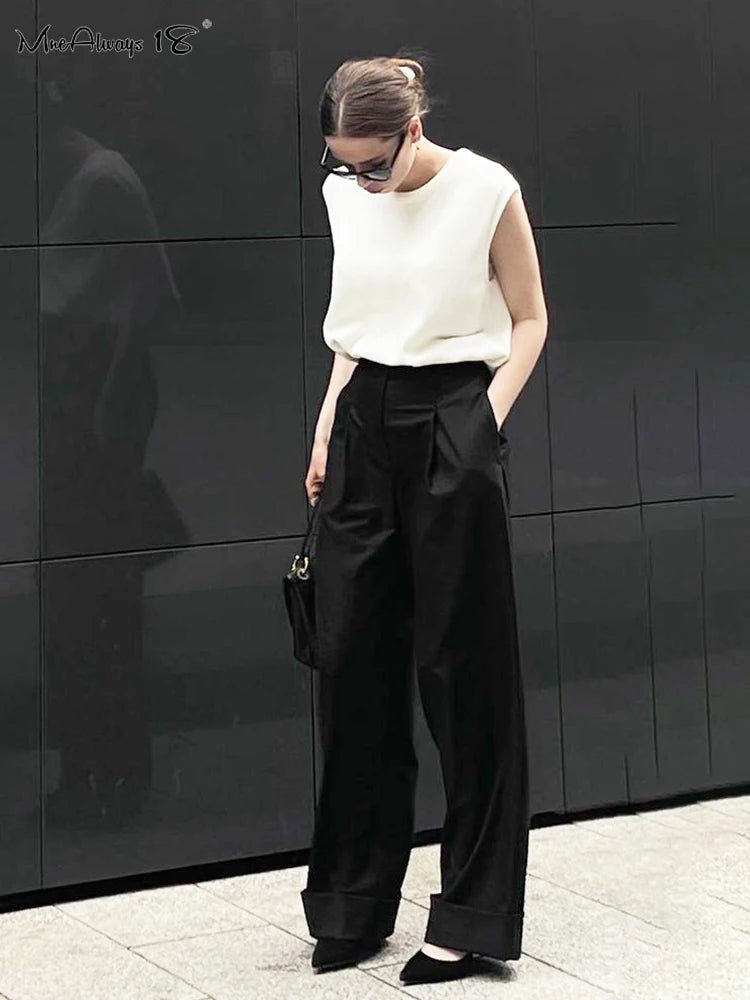 a woman in a white top and black pants