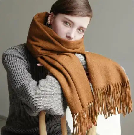 a woman wearing a brown scarf and a gray sweater