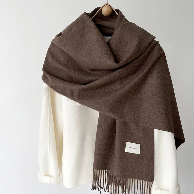 a brown and white scarf hanging on a coat rack