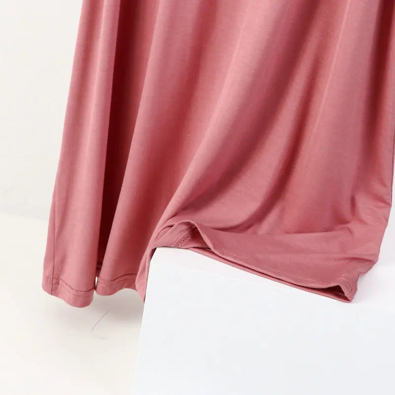 a close up of a pink shirt on a white surface