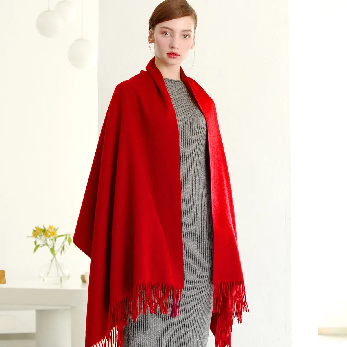 a woman standing in a room wearing a red shawl