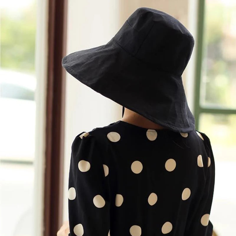 a woman wearing a black hat with white polka dots