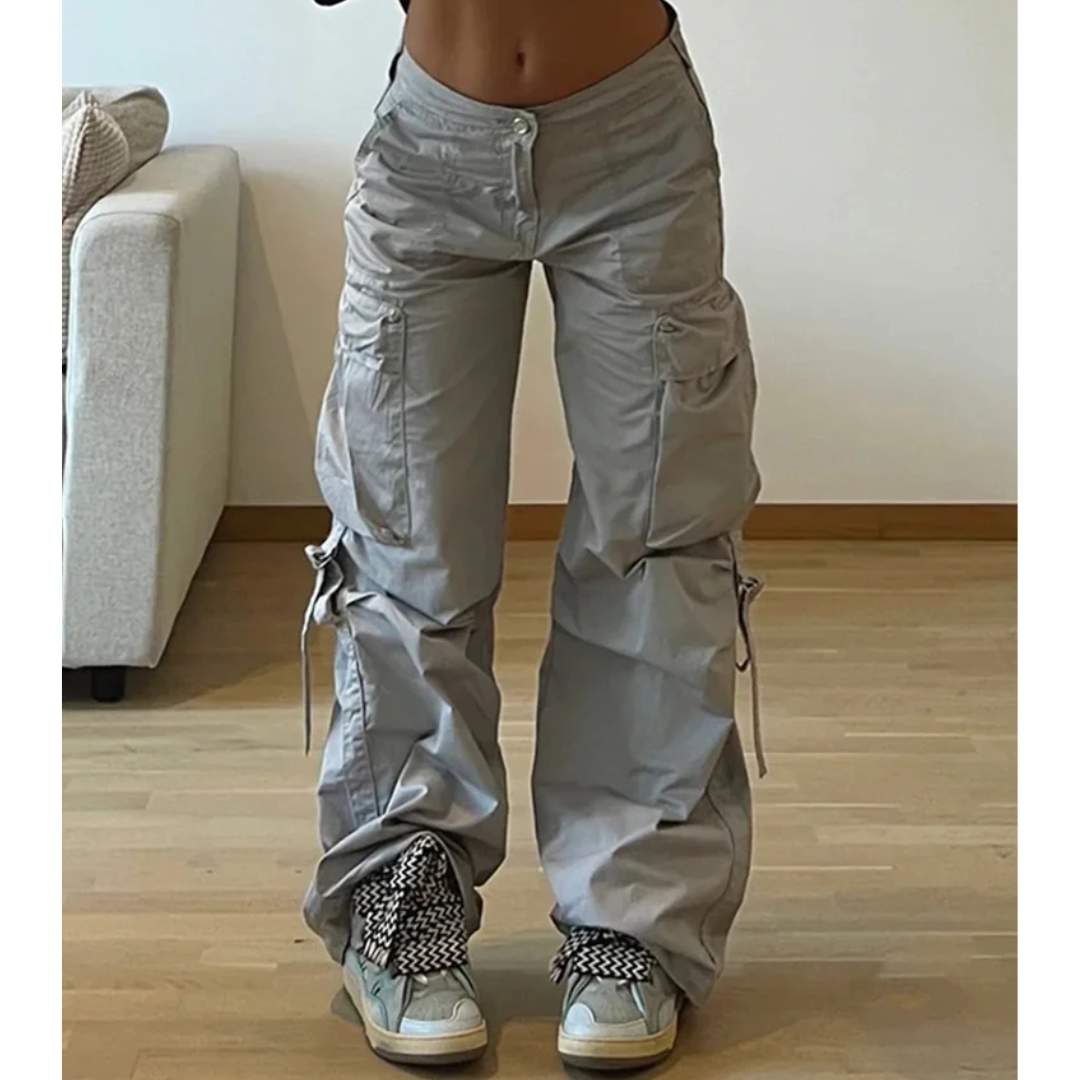 a woman in grey pants holding a cell phone