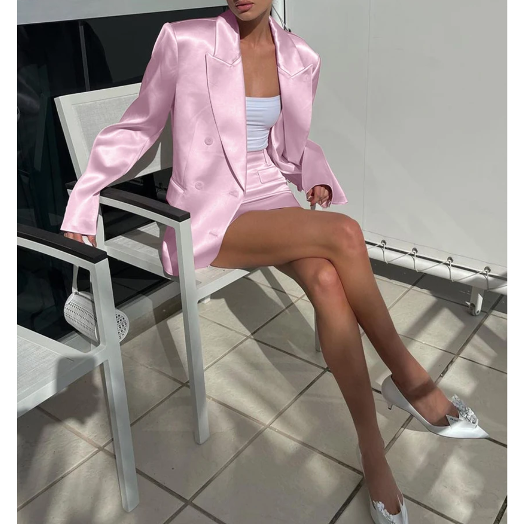 a woman in a pink suit sitting on a chair