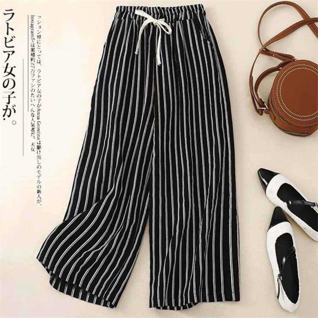 a pair of black and white striped pants next to a purse