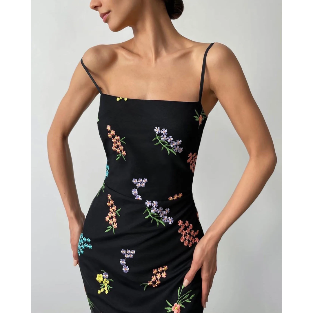 a woman in a black dress with flowers on it