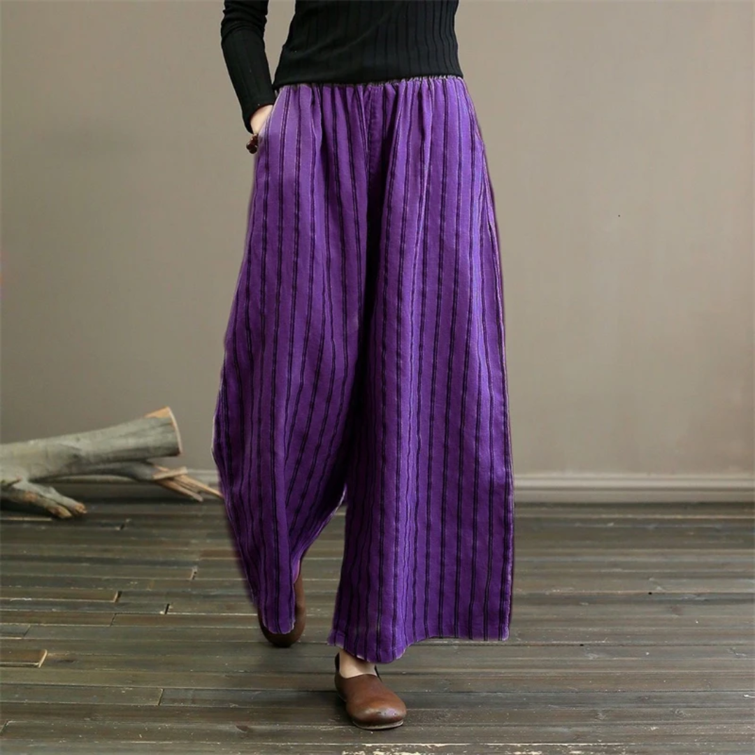 a woman in a black top and purple pants