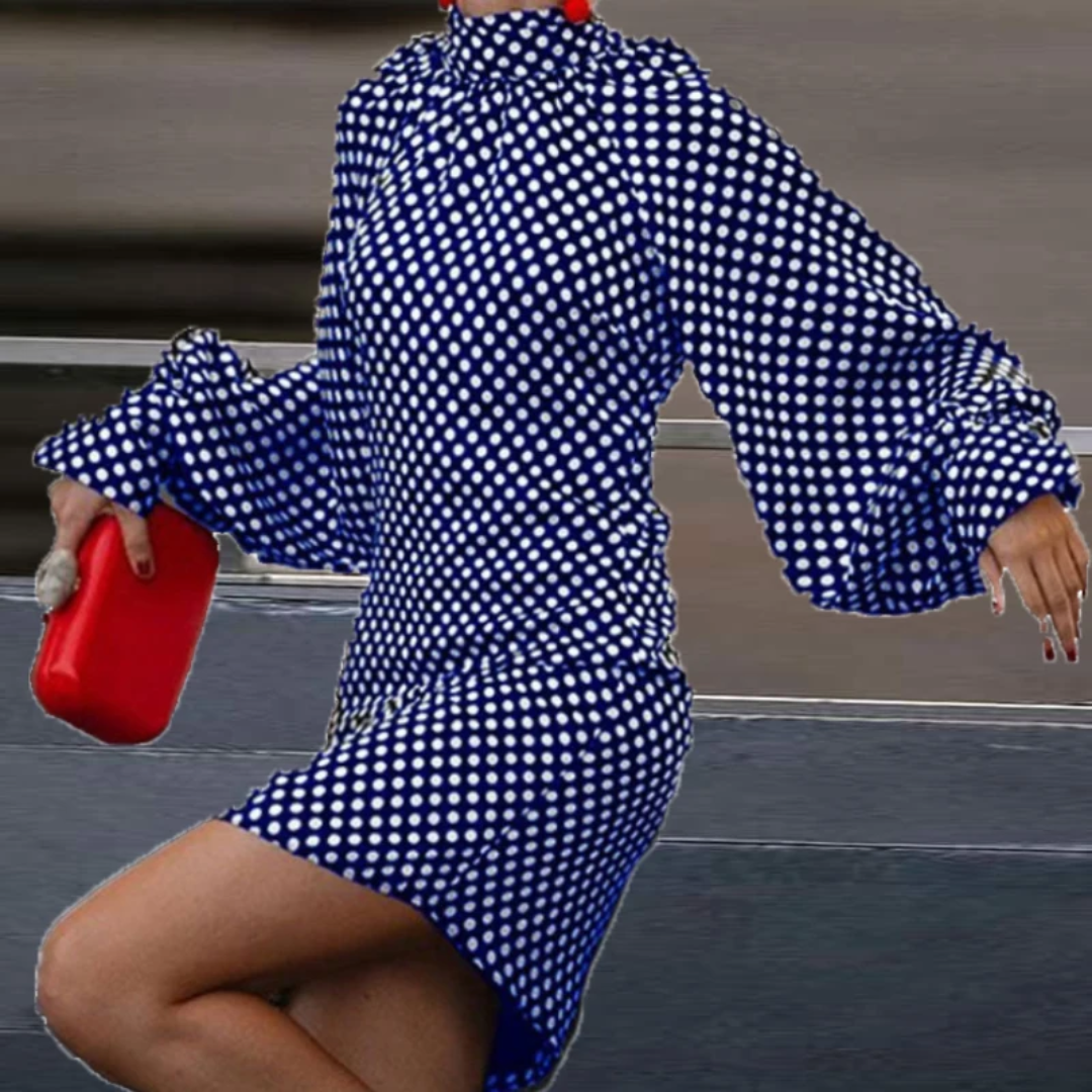 a woman in a blue and white dress holding a red purse