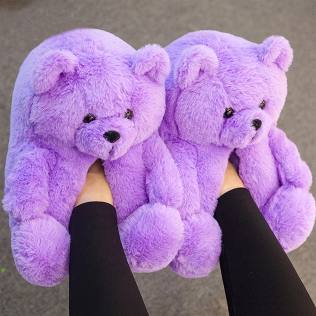 a person holding two purple teddy bears in their hands