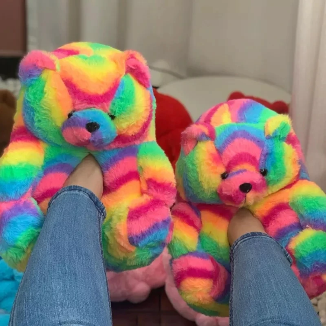 a person holding a rainbow colored teddy bear