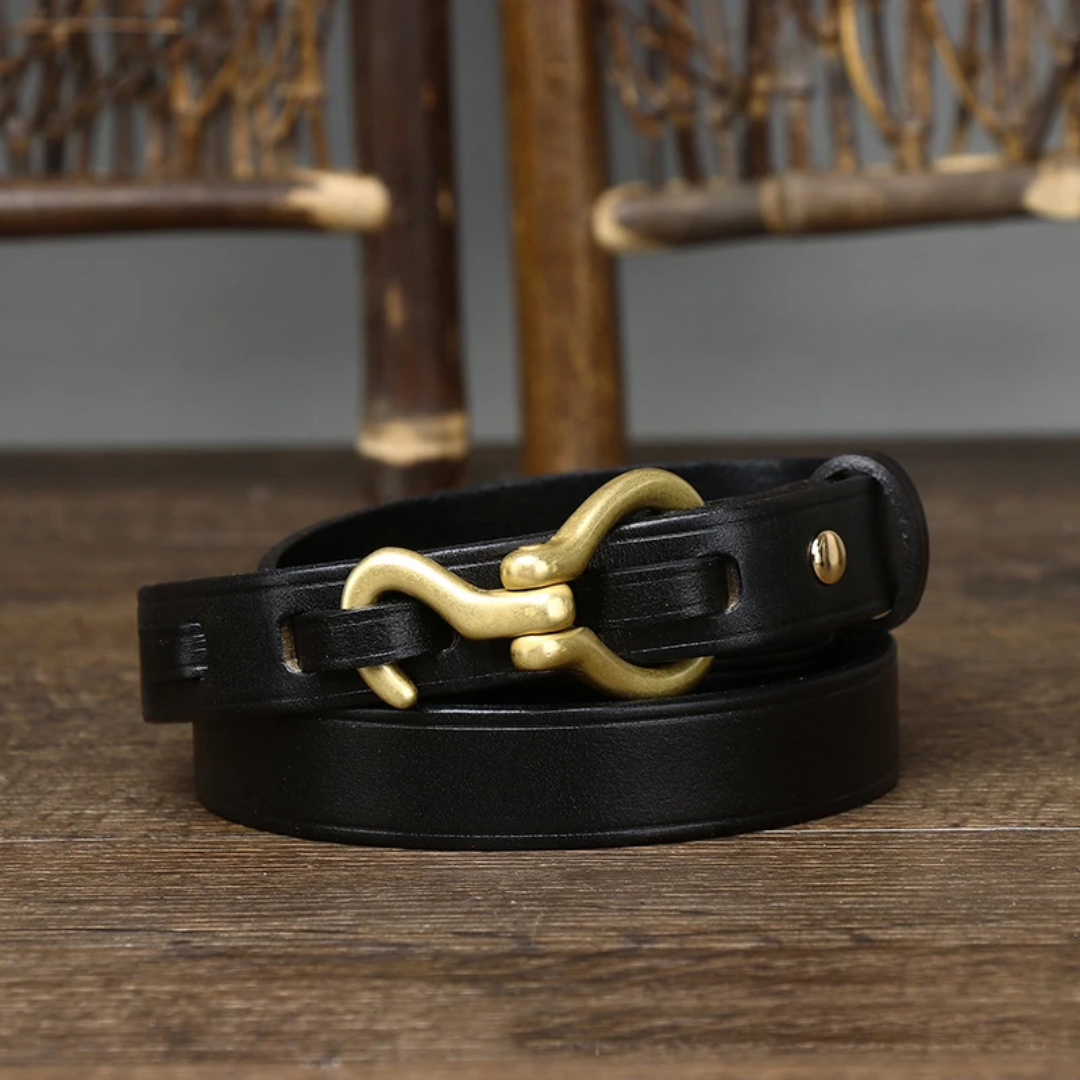 a close up of a black leather bracelet on a wooden table