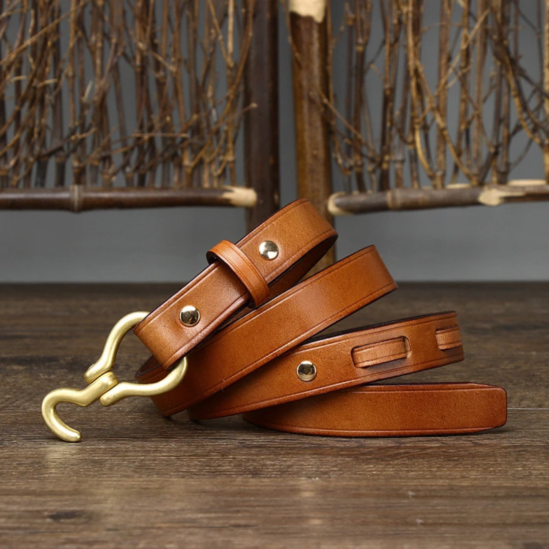 a pair of brown leather leashes on a wooden floor