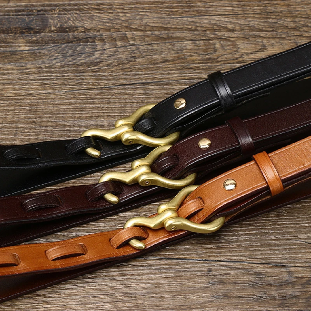 a pair of leather belts on a wooden table