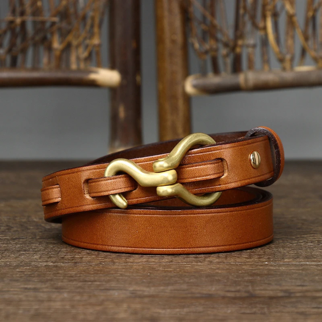 a pair of brown leather belts on a wooden table