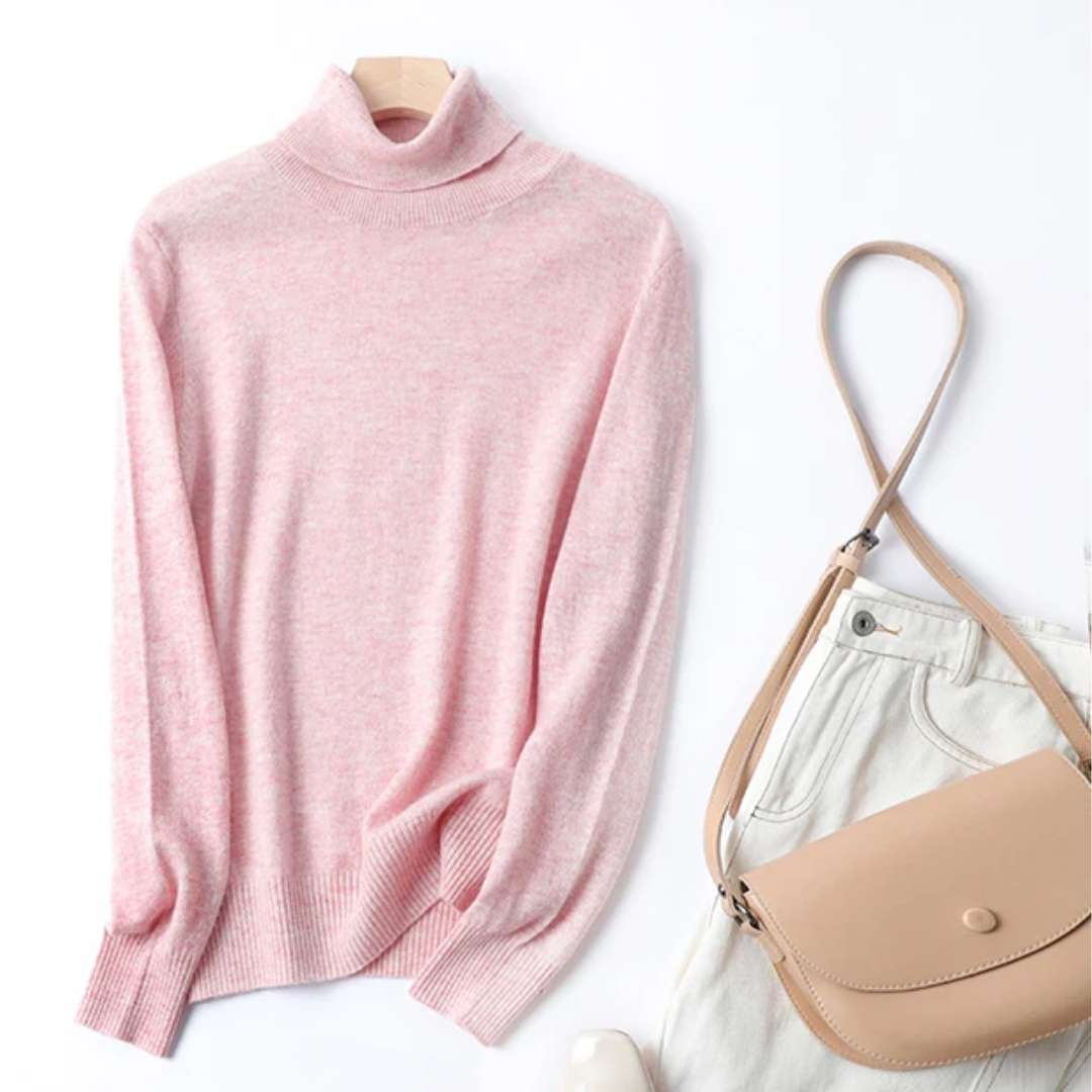 a pink turtle neck sweater next to a purse