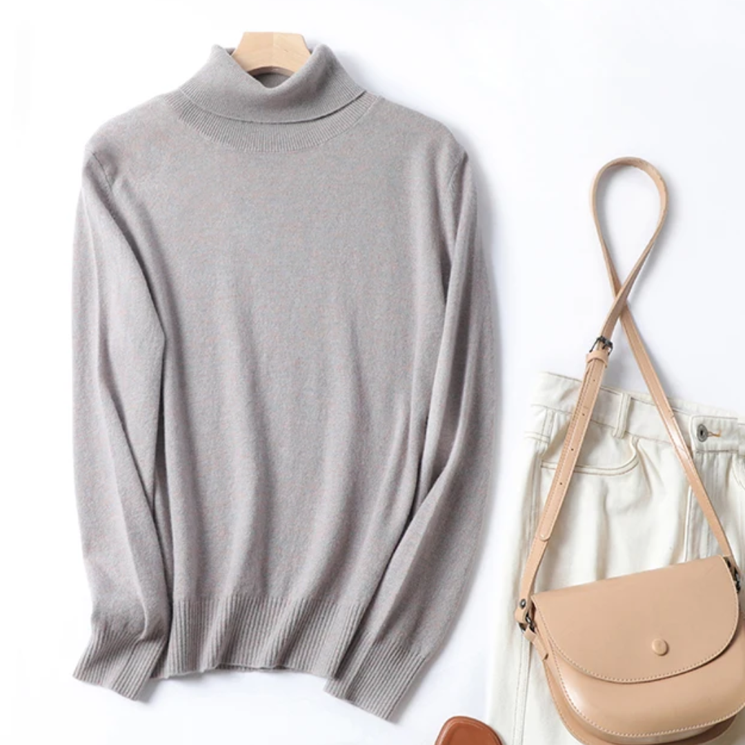 a gray sweater and white pants and a purse