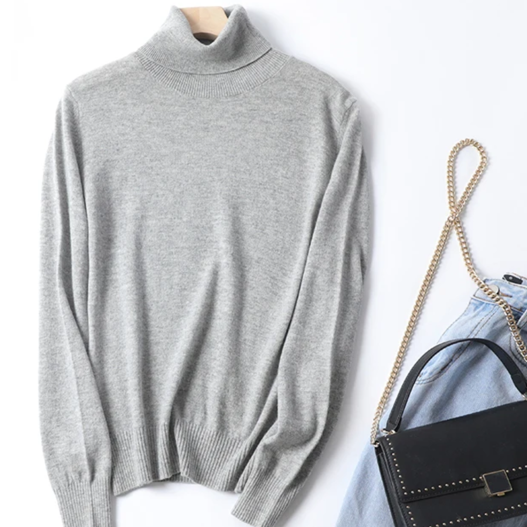 a gray turtle neck sweater next to a handbag