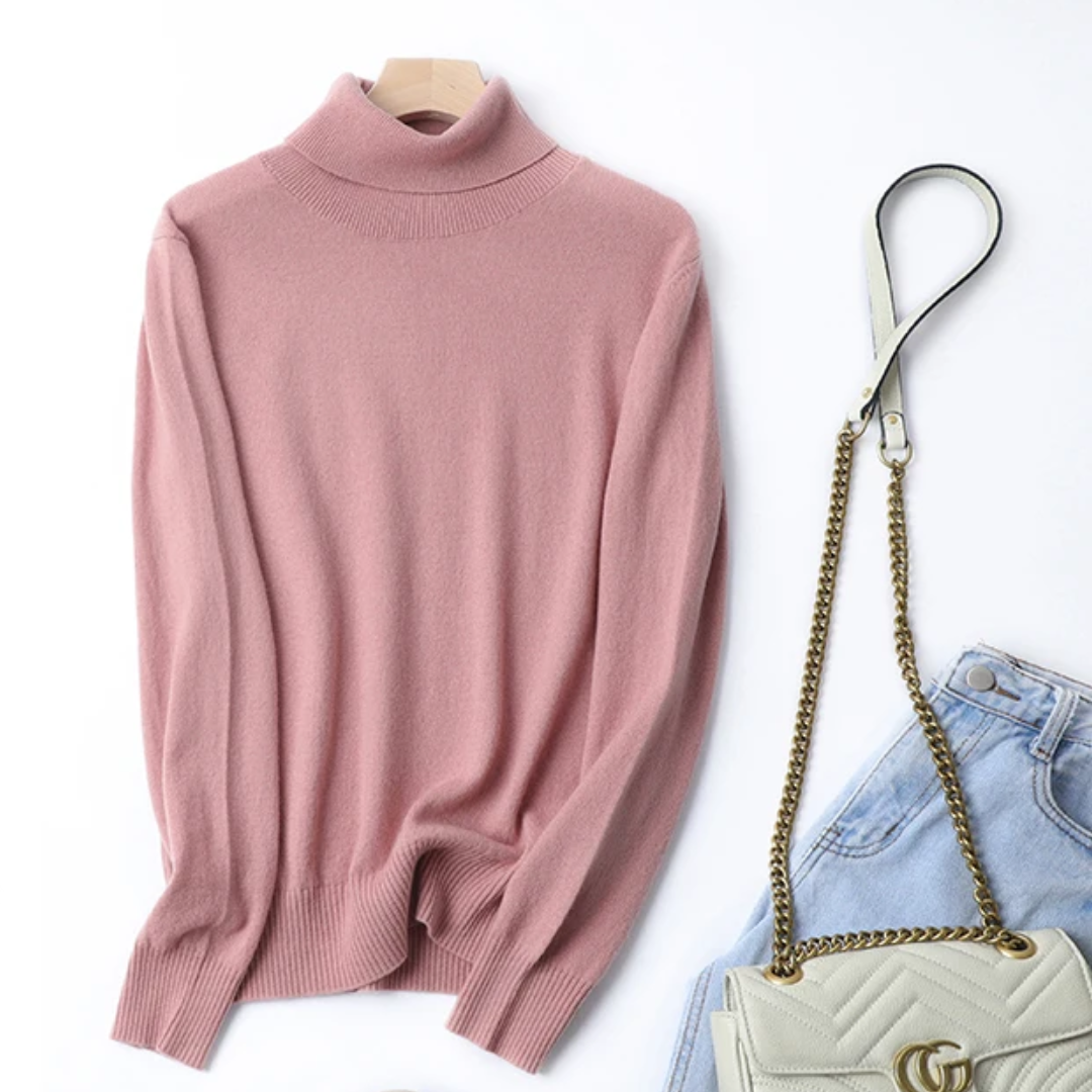 a pink sweater, jeans and a white purse