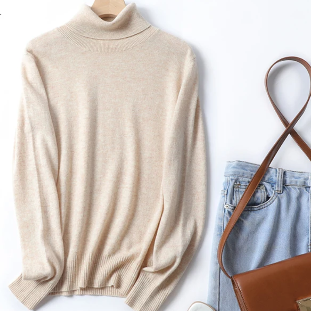a white sweater and jeans are next to a purse