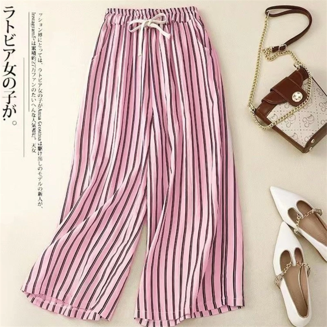 a pair of pink and white striped pants next to a purse